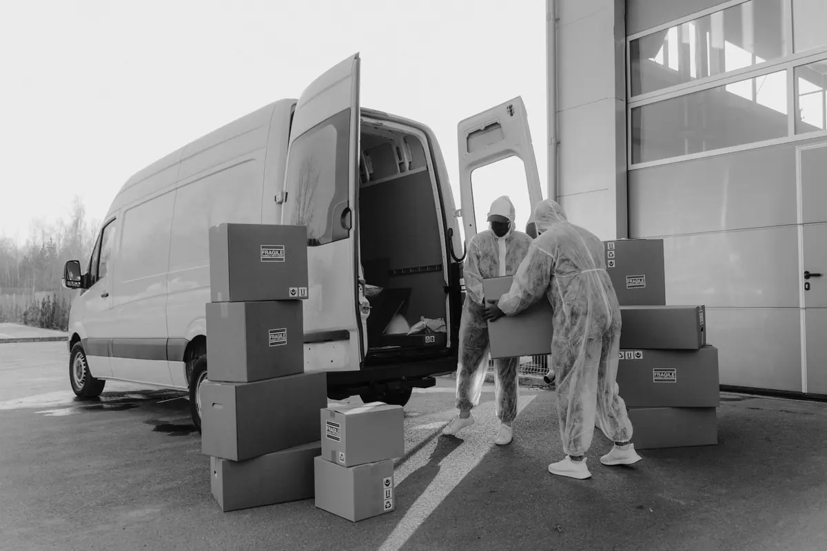 Kartons stehen an einem geöffneten Transporter zum Einladen bereit